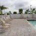 Hampton Inn & Suites Lake Wales pool deck with loungers and palm trees under cloudy skies