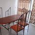 Eden Beach Saint-Louis dining area with oval table, four chairs and a glass door with patterned curtains