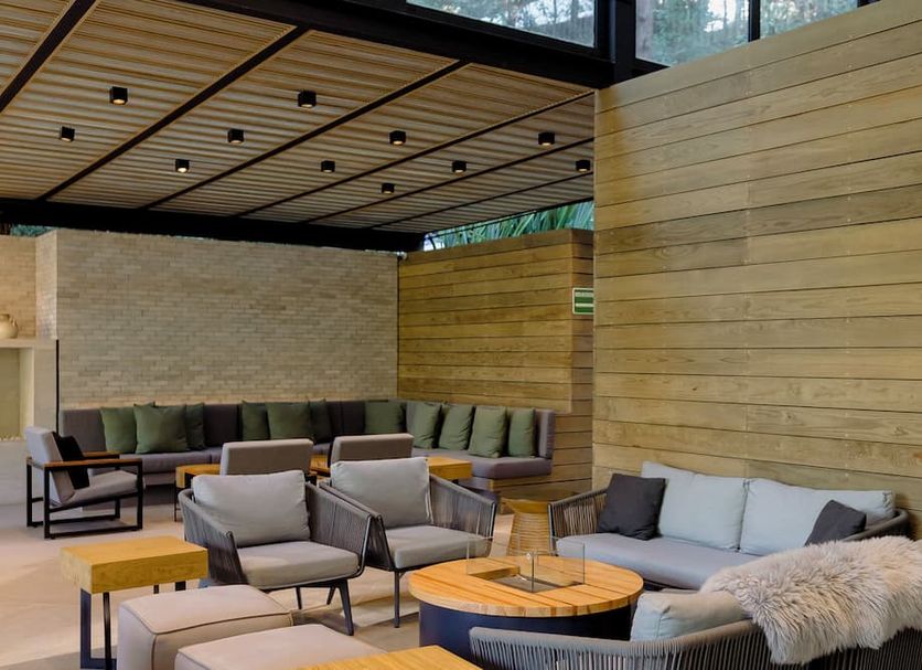 Rodavento Valle de Bravo lounge with seating area, wood walls, and floor-to-ceiling windows