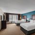 The Hotel Saratoga in Saratoga Springs guest room with two beds, window and desk