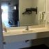 Texas Inn And Suites At La Joya bathroom vanity with mirror, towels and wall-mounted shelf