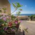 Verdemare in Macari with sea view, coastal road, and flowering plants under a sunny blue sky