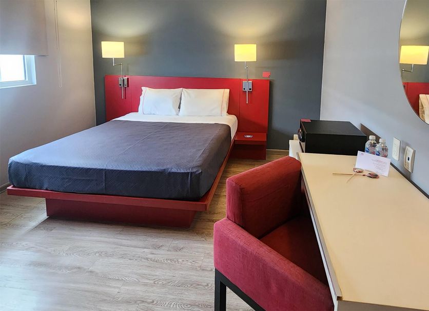 Hotel MX Forum Buenavista Cdmx guest room with bed, desk, chair and wall lamps in Mexico City