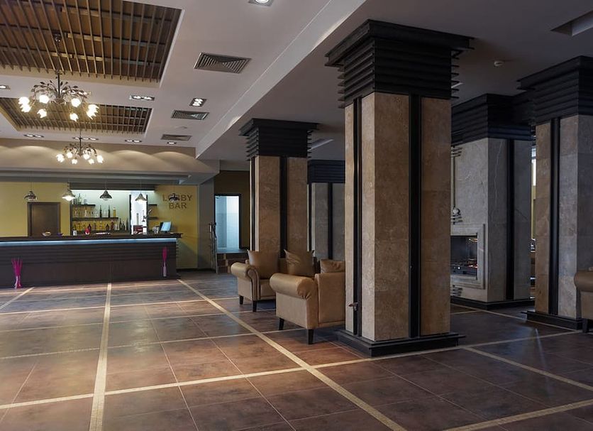 Trinity Residence Bansko lobby in Bansko with seating area, reception desk and tiled floor