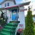 Best Motel Bowling Green office entrance with blue door, green steps, and manicured shrubs