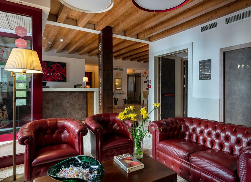 Lobby seating area at UNAHOTELS Eco Hotel Villa Costanza Venezia in Venice with red leather chairs and sofa
