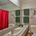 Hotel Kununurra bathroom with sink, mirror, toilet and red shower curtain in Kununurra
