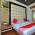 Hotel aroma classic Jaipur guest room with king bed, red accents, wood flooring, and window drapes