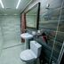Hotel Flagman, Bishkek: modern bathroom with toilet, pedestal sink, tiled walls, and glass shower enclosure