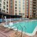 Pool area at Wyndham Vacation Resorts at National Harbor with loungers and surrounding high-rise buildings.