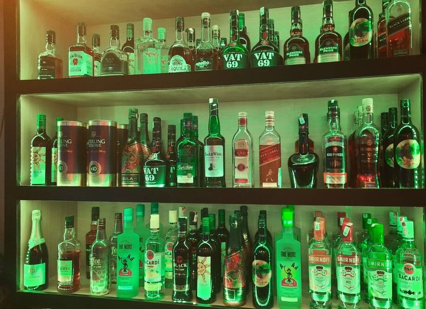 Hotel Royal Palace Havelock bar shelf with assorted liquor bottles lit in green
