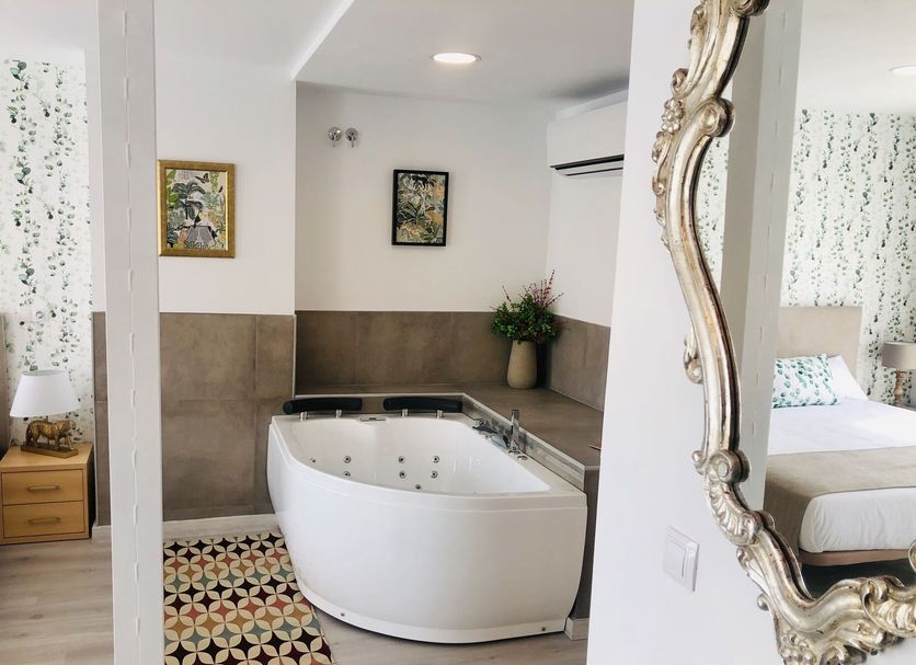 Hotel Finca Alcamino in Mompía: stylish room with a whirlpool bathtub and patterned tile floor
