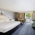 Blue Rock Resort South Yarmouth guest room with king bed, seating area, and balcony door to outdoor view