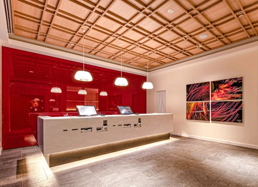 The Kanzashi Tokyo Asakusa lobby with red reception desk and wood lattice ceiling in Tokyo