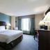 Copley Inn & Suites By OYO Akron Oh guest room with king bed, desk, lamps, and window view in Copley