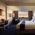 Aryaduta Makassar guest room with king bed and city sunset view in Makassar