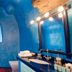 Vallas Apartments & Villas in Firostefani features a blue cave-style bathroom with vanity and window