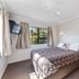Knightsbridge Court Motor Lodge room in Blenheim with queen bed, wall-mounted TV, and window view