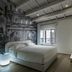 Lords of Verona Luxury Apartments in Verona bedroom with mural wall, bed, and balcony window