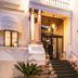 Hotel De la Ville in Riccione entrance with lit lanterns and stone steps at dusk