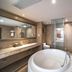 Aimoer Hotel Foshan bathroom with freestanding tub, glass shower, double vanity and towel rack