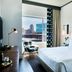 The Casso, Raleigh guest room with city view, king bed, desk, and upholstered chair by a window