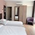 Tumike Hotel Bentong room with two single beds, wardrobe, chair, and air conditioner in Bentong