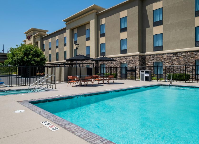 Hampton Inn Turlock outdoor pool with lounge chairs and shaded patio beside the hotel