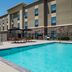 Hampton Inn Turlock outdoor pool with lounge chairs and shaded patio beside the hotel