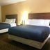 Passport Inn and Suites - Middletown room with two beds, bedside lamp, and desk chair