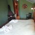 Pousada Atalaia room in Campos do Jordão with bed, wood stove and green walls