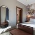 Axyhotels Innstyle Milano room in Milan with double bed, abstract mural wall, and oval mirror