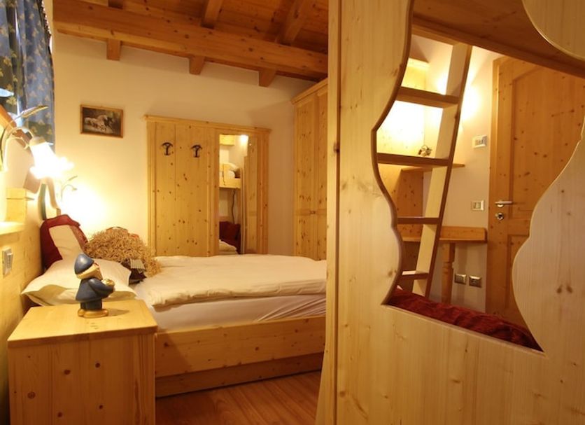 B.& B. Corradini in Castello di fiemme, cozy wood-paneled guest room with sloped ceiling and bed