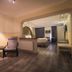 Hotel am Markt Saarburg guest room with seating area, bed, and open archway to bedroom