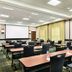 Hyatt House Denver Airport meeting room in Denver with rows of tables, black chairs, and projector screen