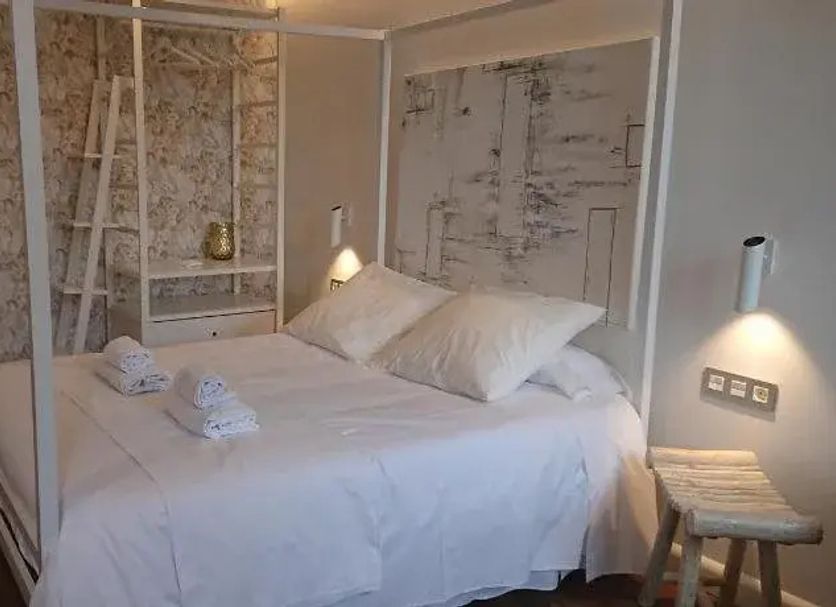 Hotel San Nikolas Sea Views in Hondarribia: cozy bedroom with canopy bed and wall-mounted reading lights