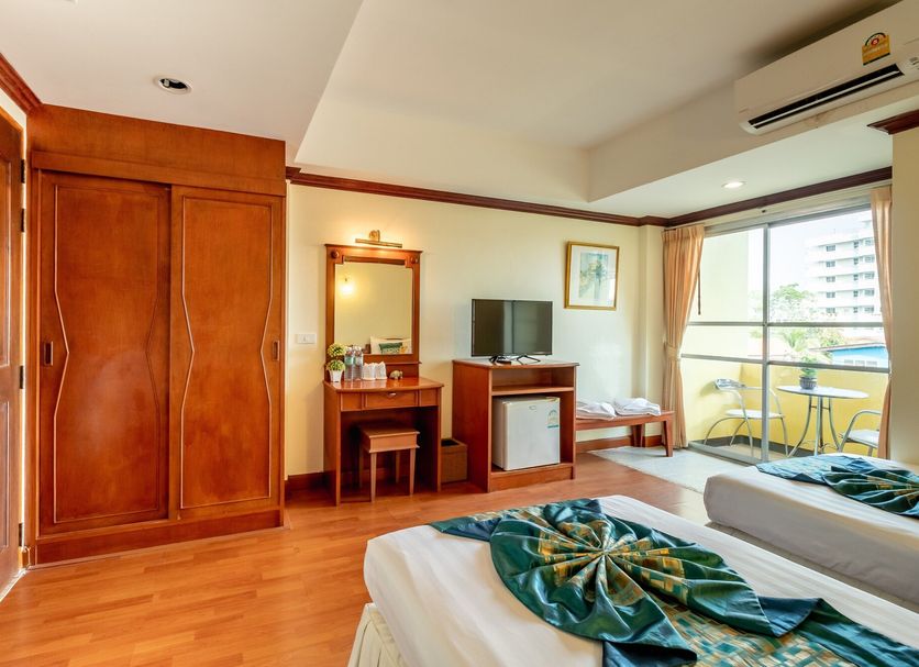 Chomsin Hua Hin room with wood wardrobe, twin beds, TV, desk, and balcony view in Hua Hin