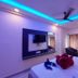 Hotel Sea Coast, Digha room with blue LED ceiling, wall-mounted TV, bed, chairs and curtains