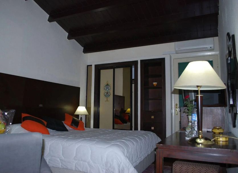 Moulay Yacoub hotel room in Fez with bed, lamps, and balcony doors