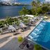 Hilton Garden Inn San Juan Condado pool deck with loungers beside a river and city skyline