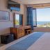 Hotel El Mirador Puerto Escondido room with ocean view, bed, desk, and window curtains