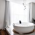 Be Playa Hotel Boutique & Rooftop Bar in Playa del Carmen with a round soaking tub and lounge chairs by tall windows