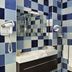 Hôtel de l'Abeille Orléans bathroom with blue checkered tile, sink, mirror, shower and wall hair dryer