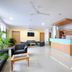 Hotel De Ecobiz in Ahmedabad lobby with front desk, seating area, potted plant and ceiling fan
