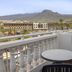 Balcony with table and chair at whala!tenerife in Arona, overlooking mountains and resort buildings.