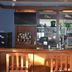 Quality Inn Perrysburg hotel bar with wood counter, liquor bottles, TVs and glass display shelves
