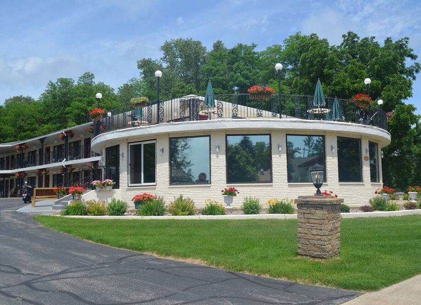 Amber's Inn & Suites in Wisconsin Dells with a curved exterior, rooftop patio, and landscaped lawn