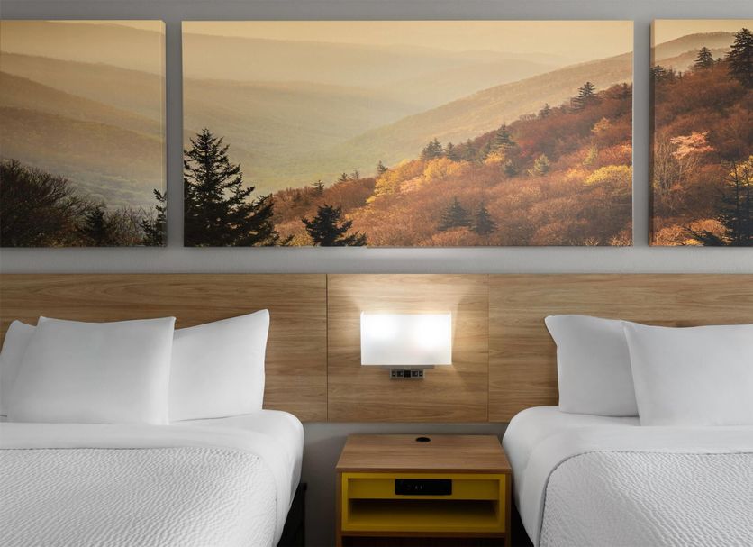 Days Inn by Wyndham Harrisonburg room with two beds and mountain landscape wall art