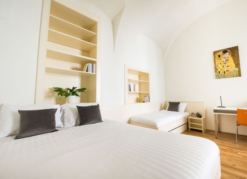 myNext - Johannesgasse Apartments in Vienna: bright triple room with three beds, desk and shelves