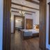 Casa Chitic in Braşov bedroom with exposed beams, wood furniture, and mirrored doorway
